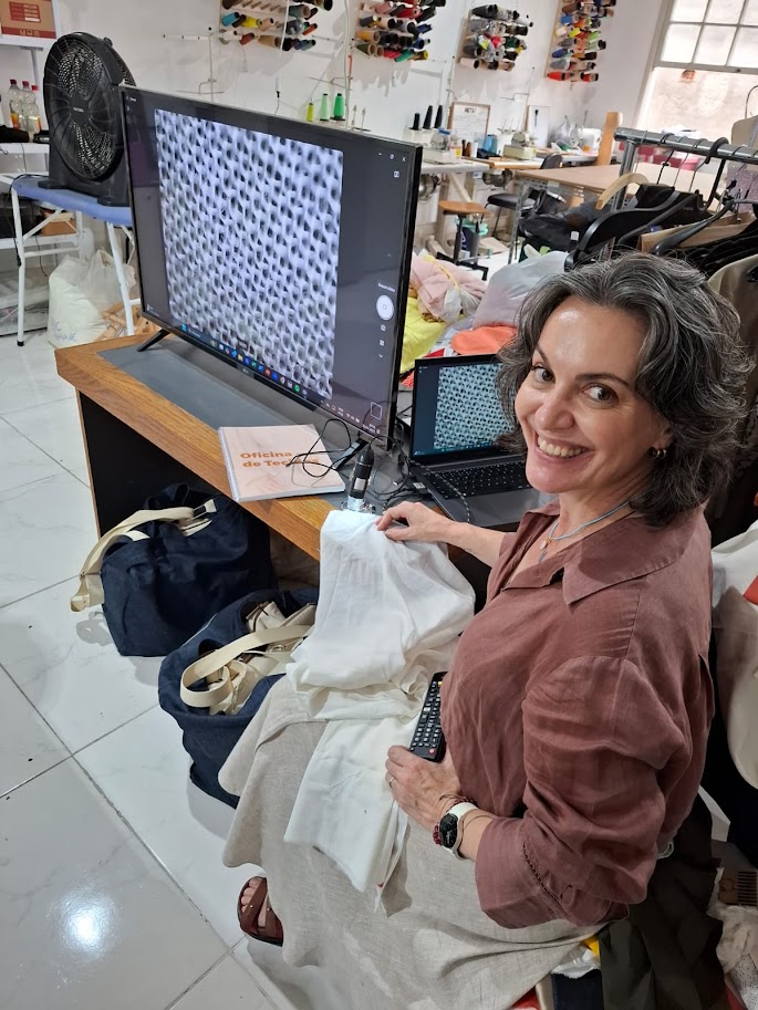 Ana Scalea analisando a estrutura de um tecido ampliada em microscópio digital, durante a Oficina de Tecidos